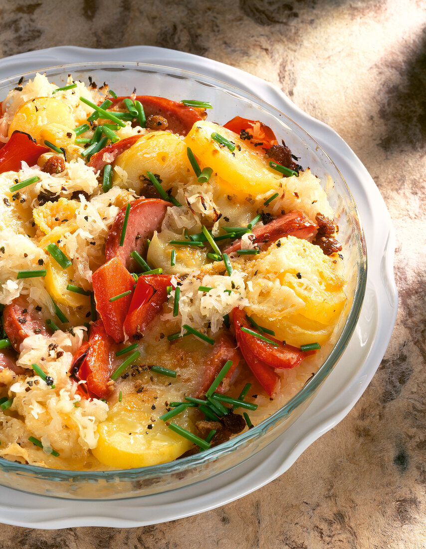 Close-up of sauerkraut gratin with peppers, potatoes and chives in bowl