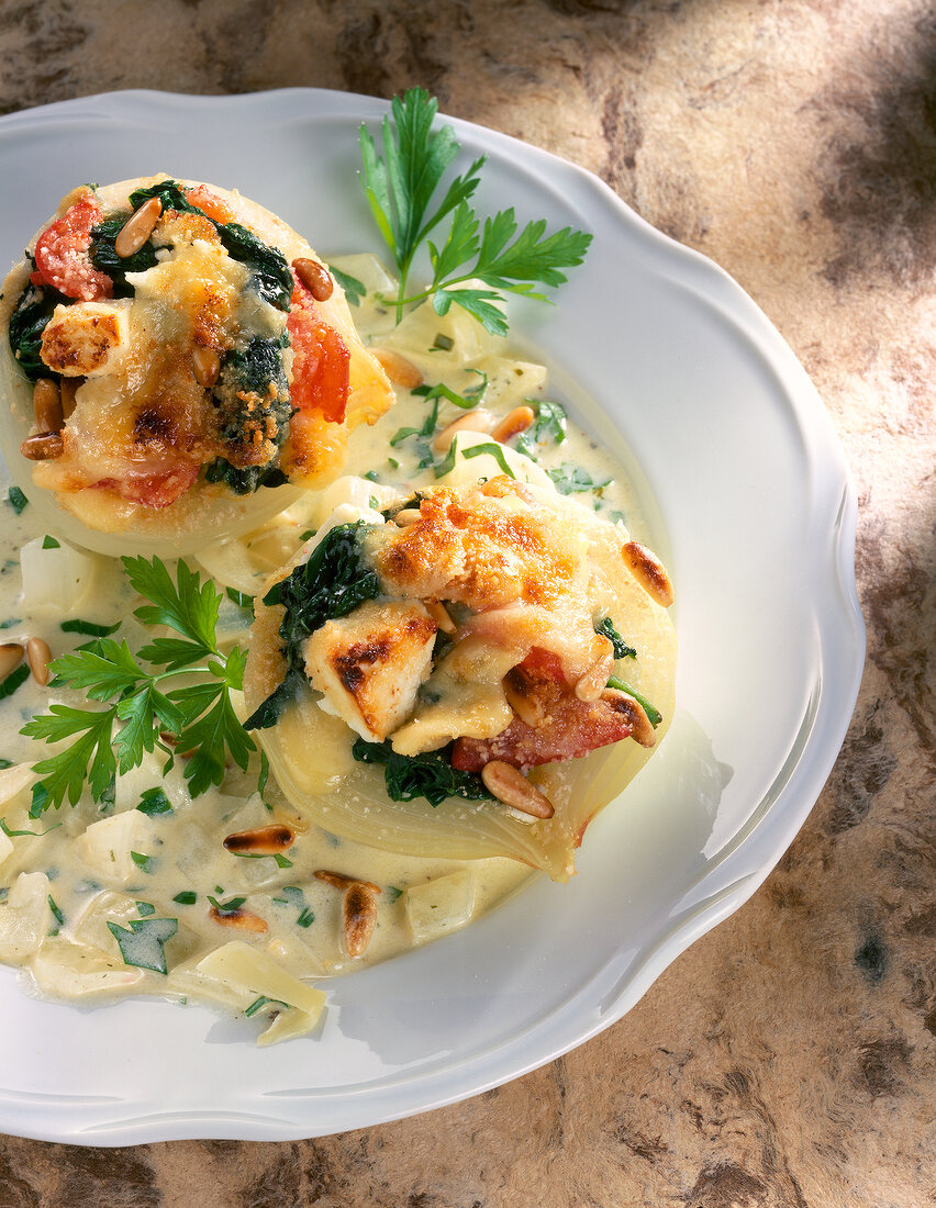 Close-up of onions stuffed with spinach, tomatoes and cheese on plate