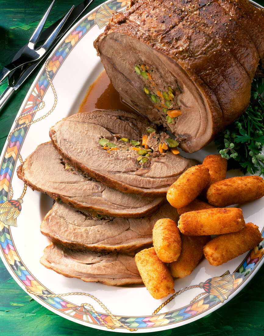 Close-up of roast wild boar with potato dumplings on plate
