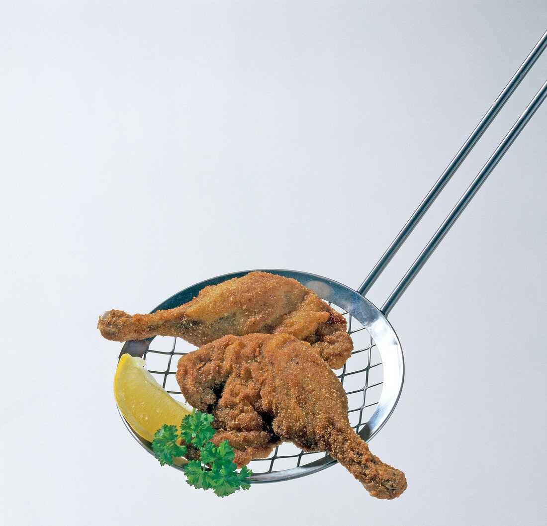 Pieces of fried ducks with lemon on skimmer