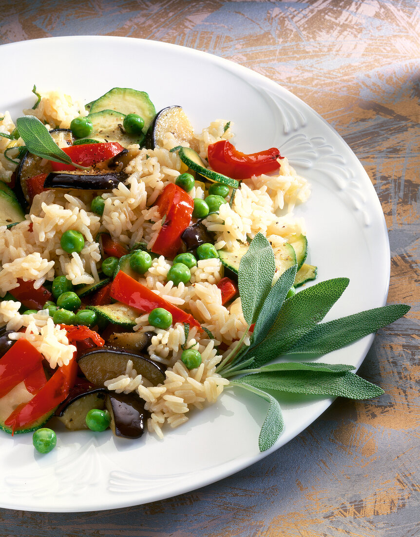 Close-up of vegetable risotto with peas, peppers, zucchini, onions and eggplant on plate