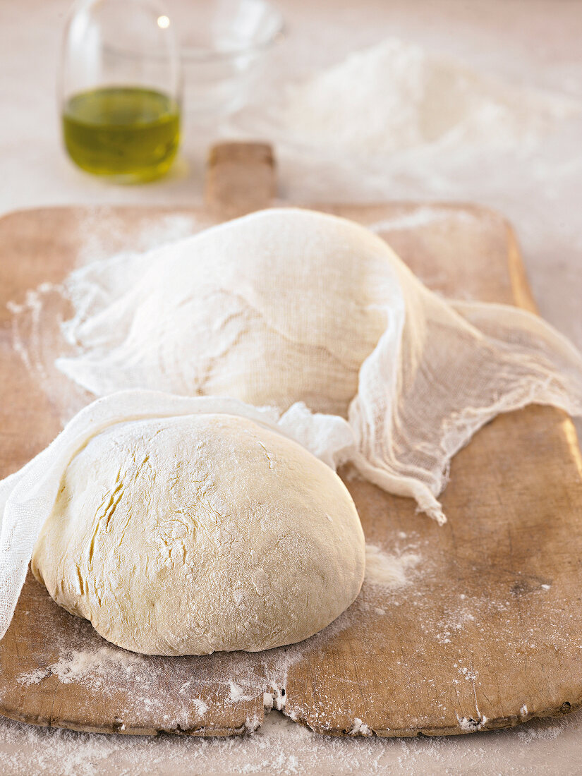 Raw pizza dough made in bales dusted on wooden board