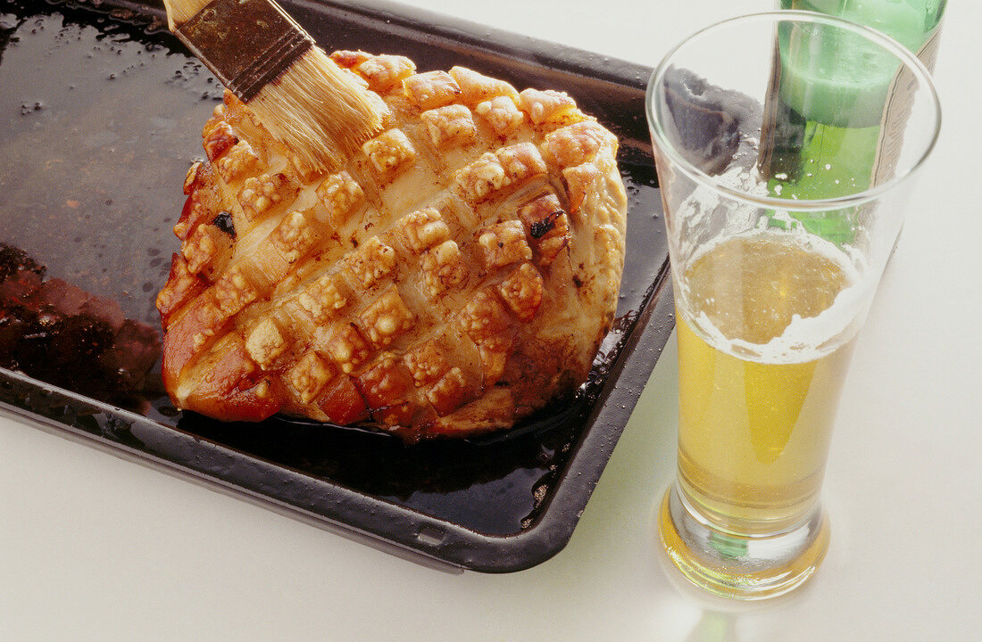 Roasted pork being brushed with beer, step 3