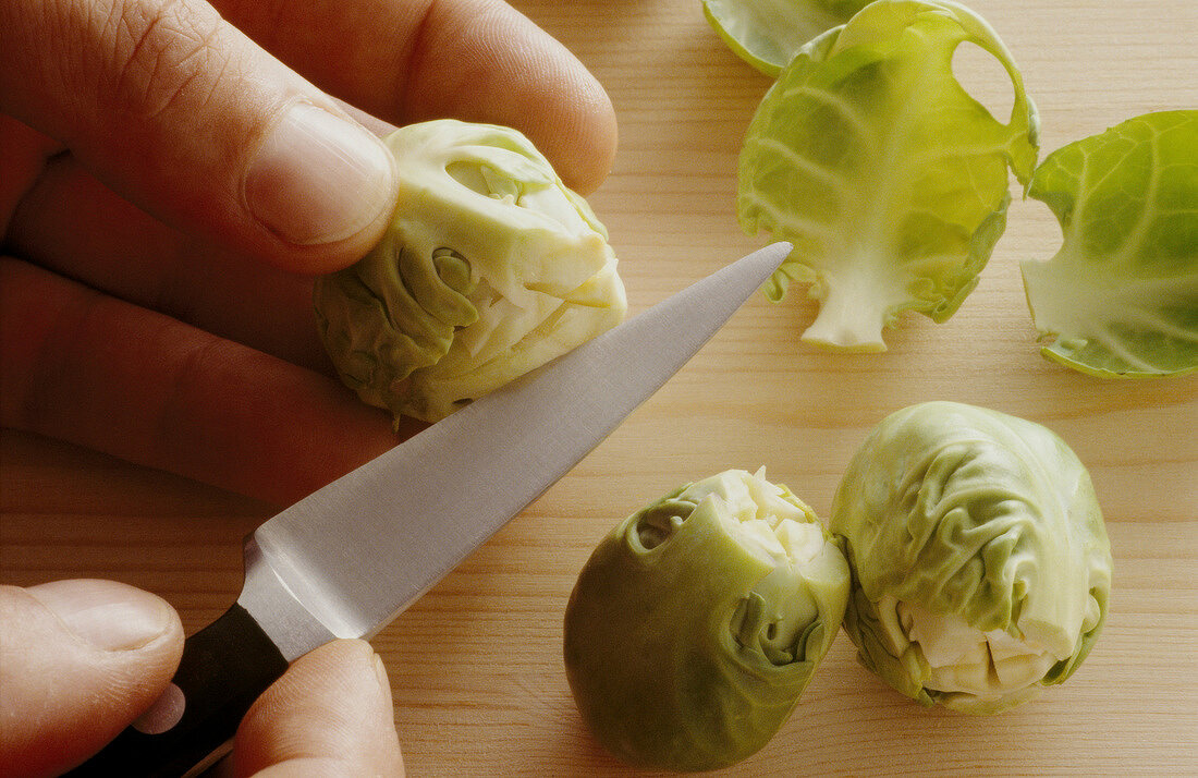 Brussels sprout being carved crosswise with knife