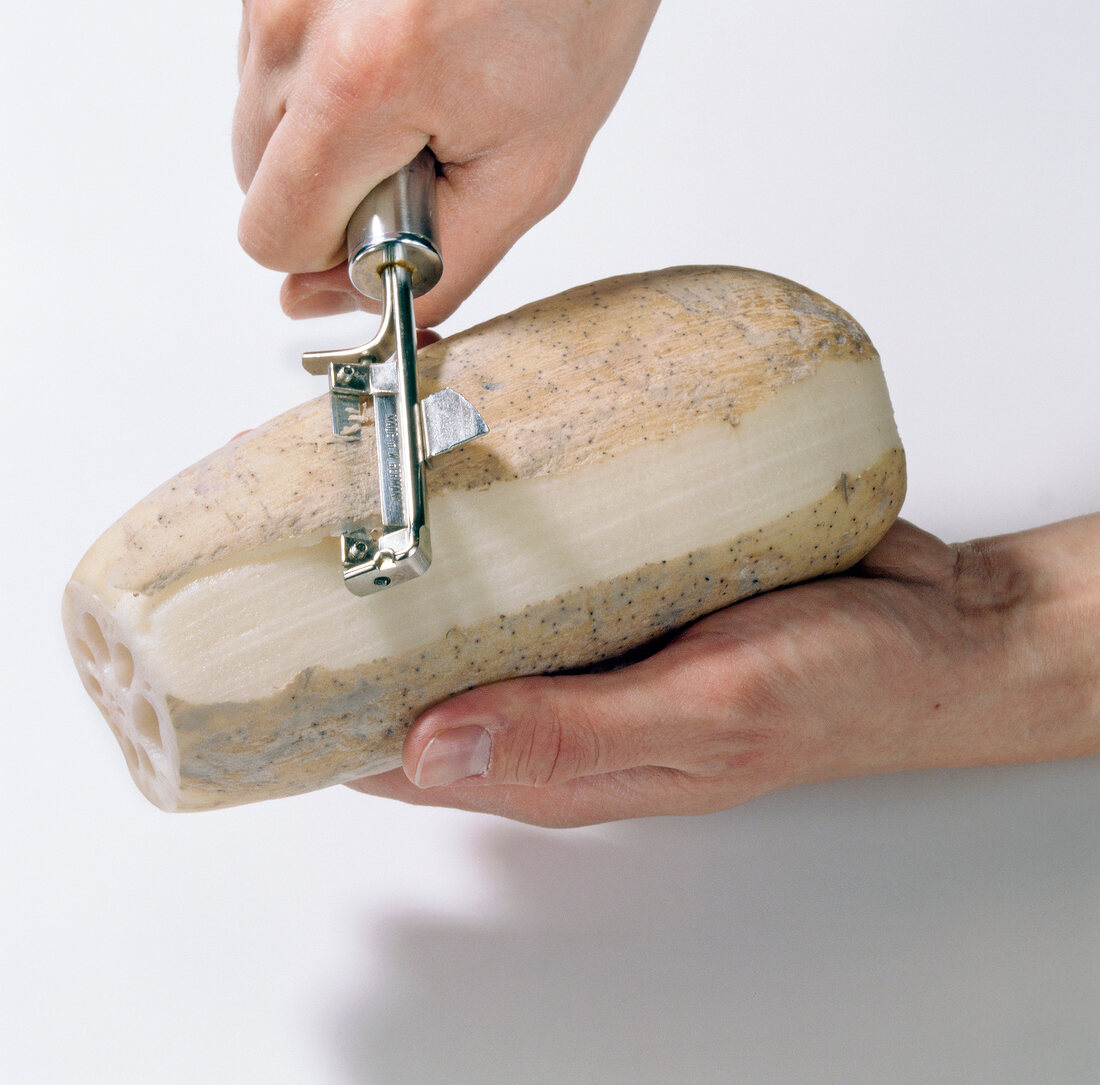 Close-up of hands peeling lotus root, step 2