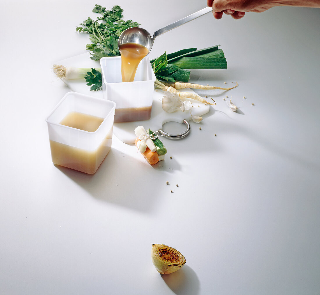 Pouring stew in jar with vegetables on white, copy space