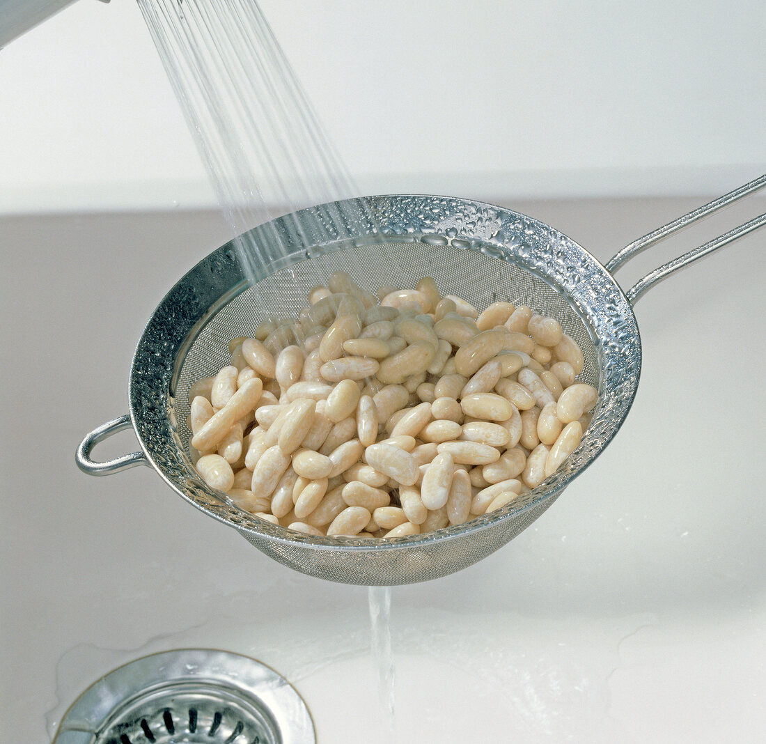 Close-up of washing white beans in sieve, step 3