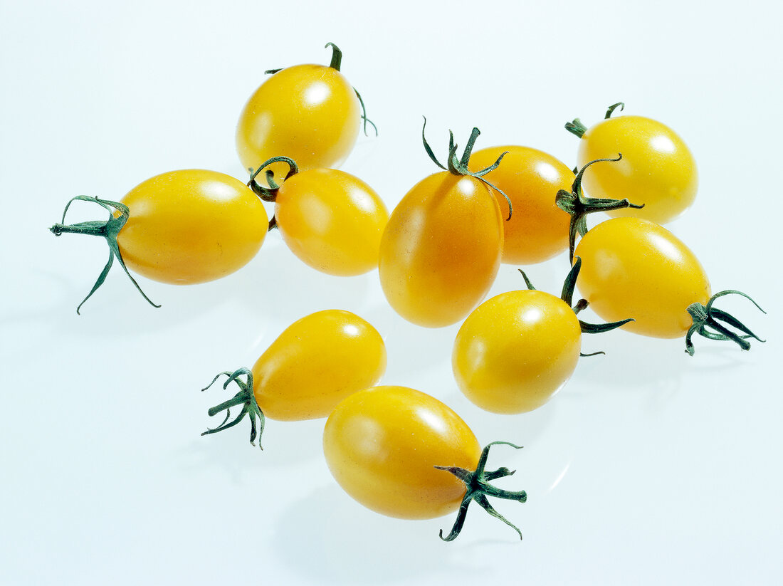 Yellow cherry tomatoes on white background