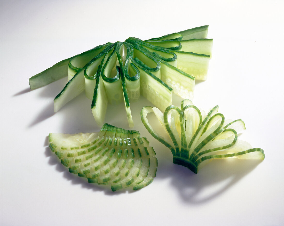 Close-up of carved cucumbers on white background