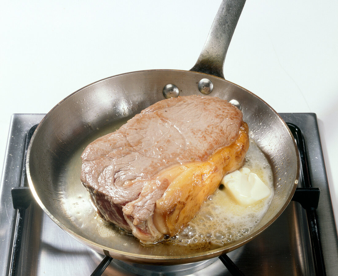 Sirloin steak with butter in frying pan, step 2