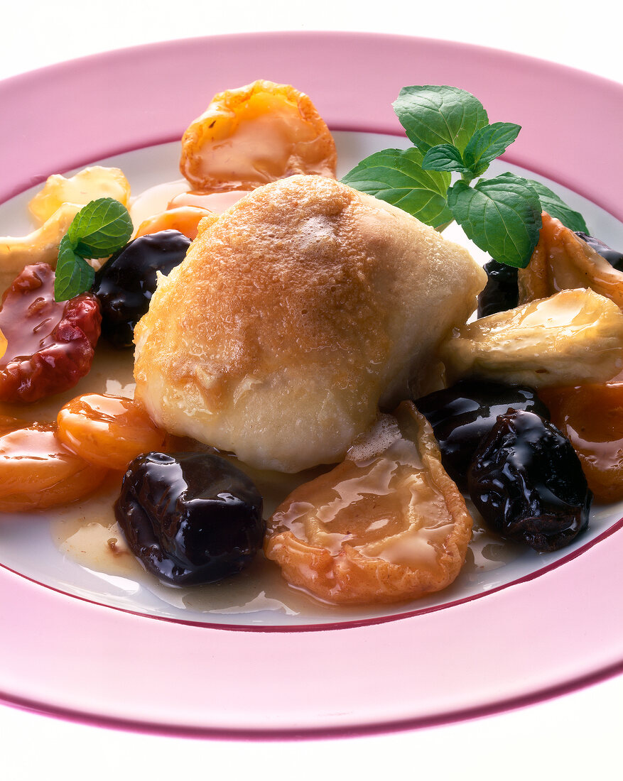 Close-up of steamed dumplings with stewed fruits on plate