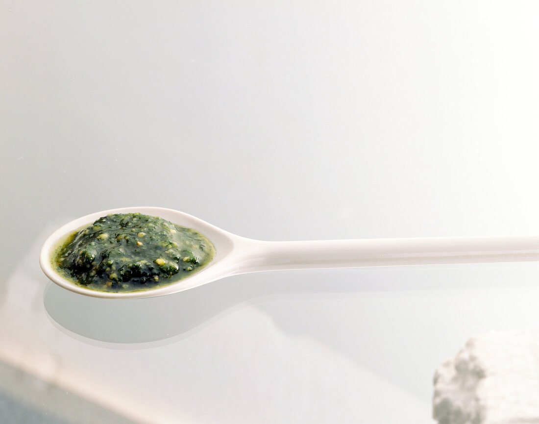 Close-up of pesto made with basil and pine nuts on a spoon