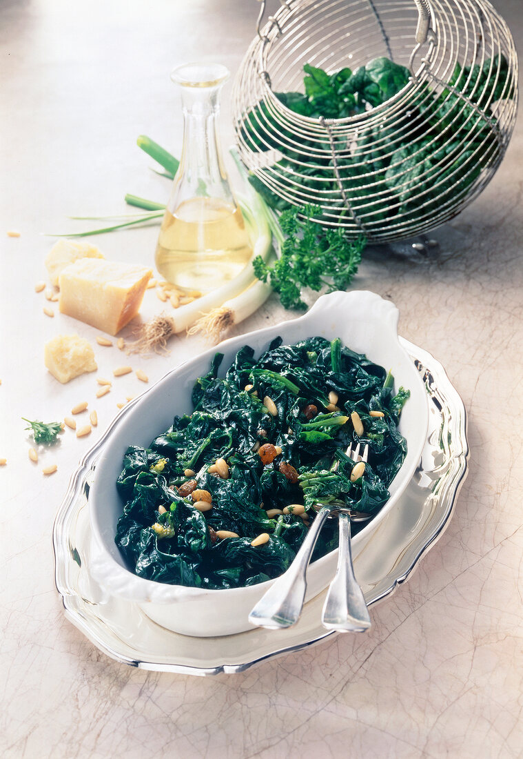 Spinach with pine nuts and parmesan cheese in serving dish