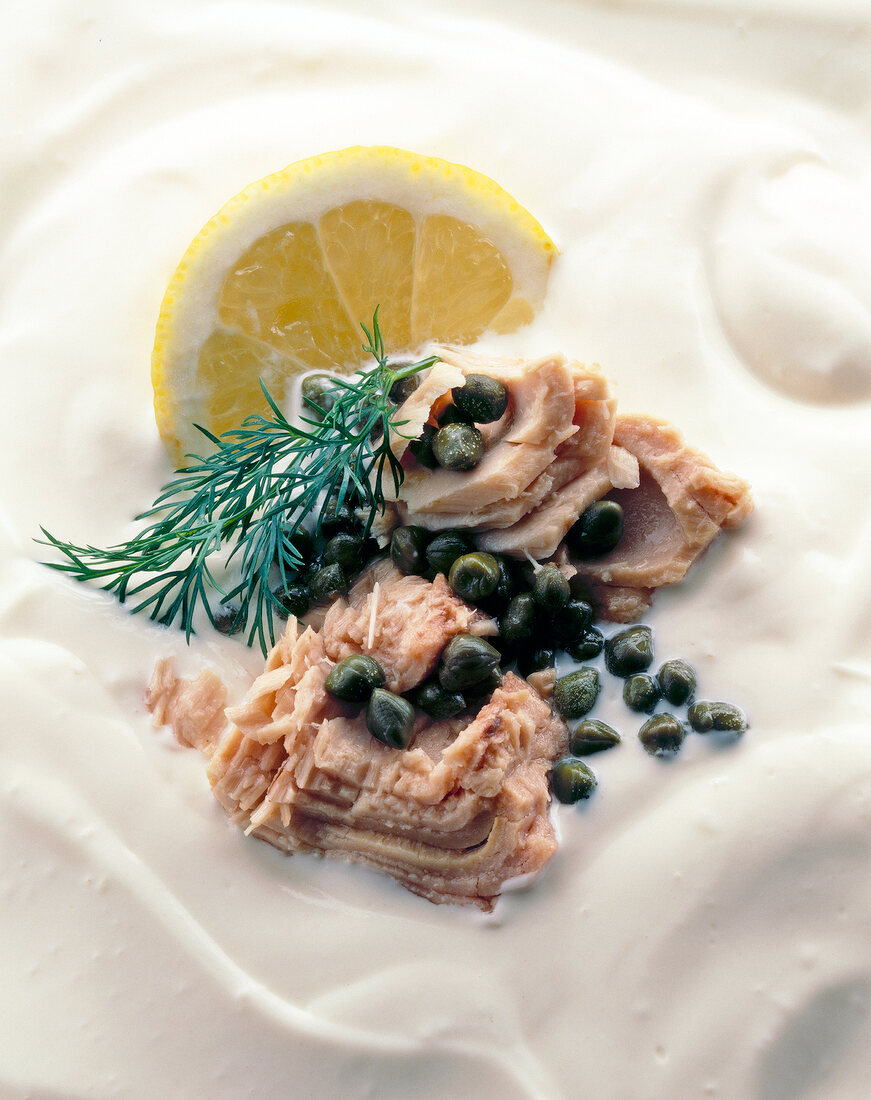 Close-up of yogurt sauce with lemon, tuna and capers