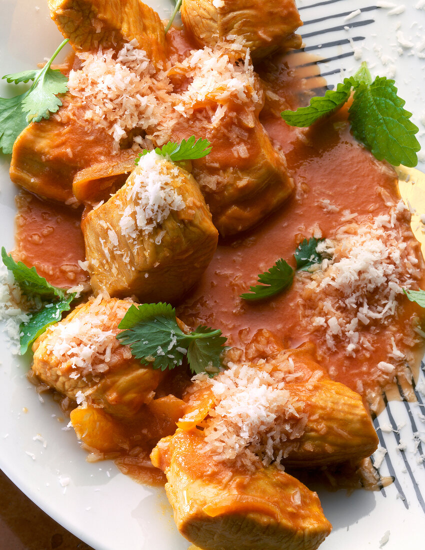 Close-up of turkey meat in tomato and coconut sauce on plate