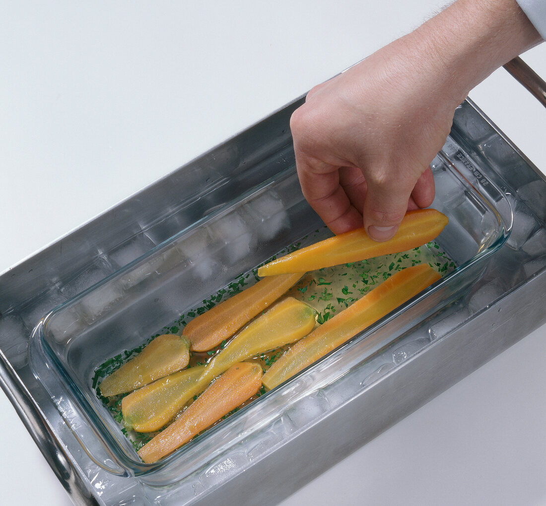 Placing slices of carrots in glass bowl for preparation of aspic, step 3