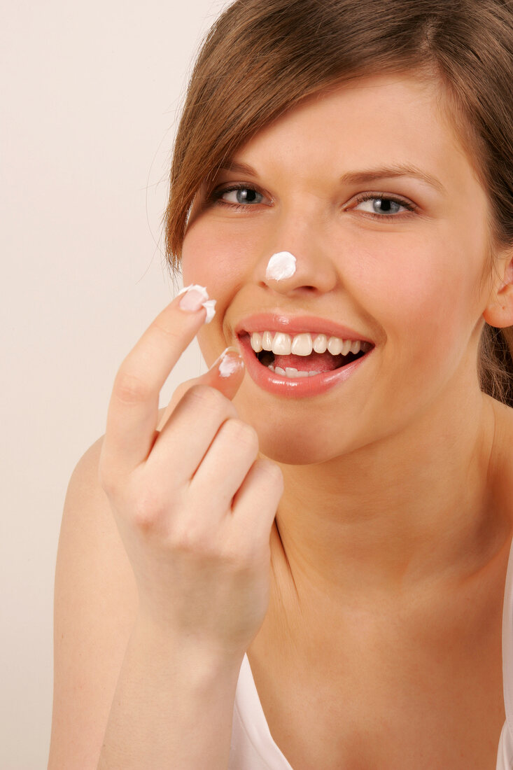 Portrait of Magdalena woman with cream on her nose and finger, laughing