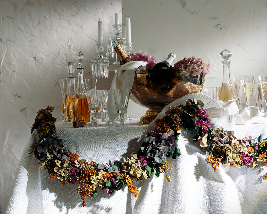 Table with champagne, glasses, and dried flower garland