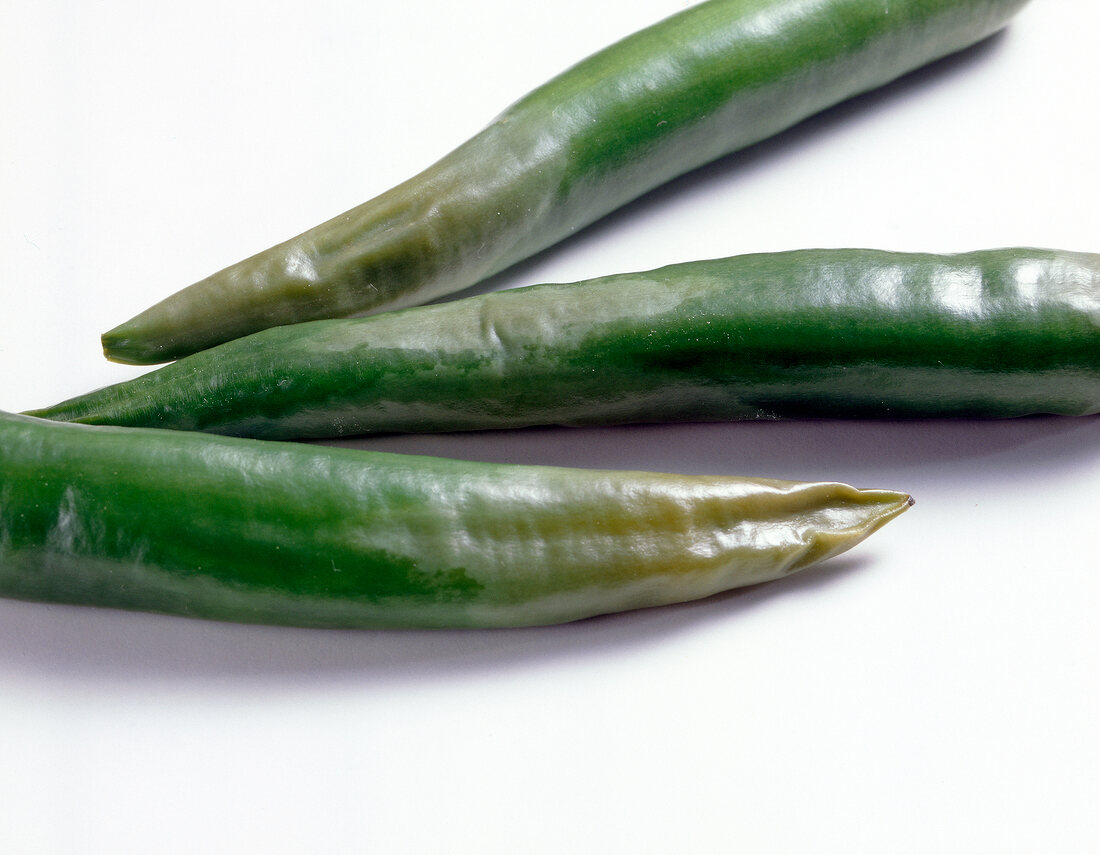 Close-up of three green putrid chillies 