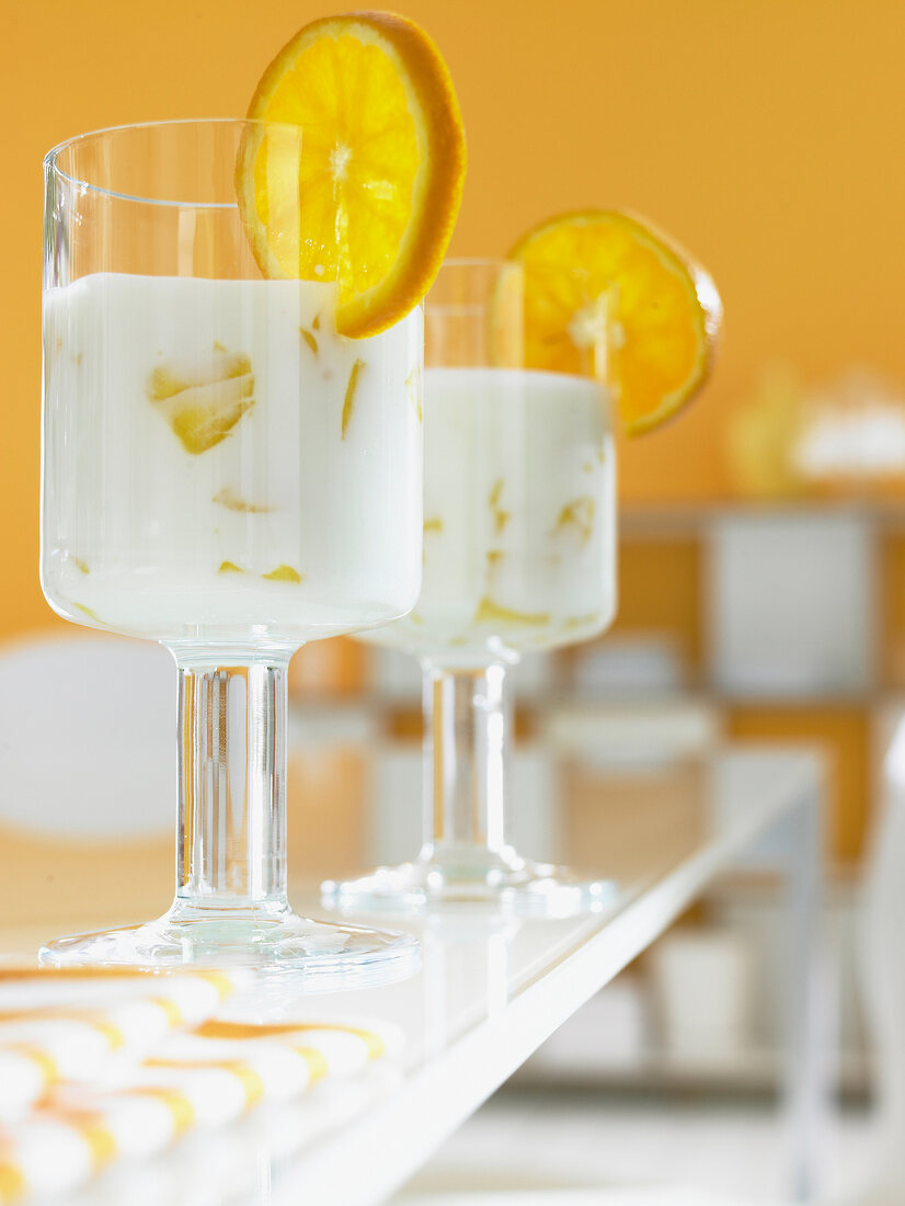 Two glasses of dessert with yogurt and orange