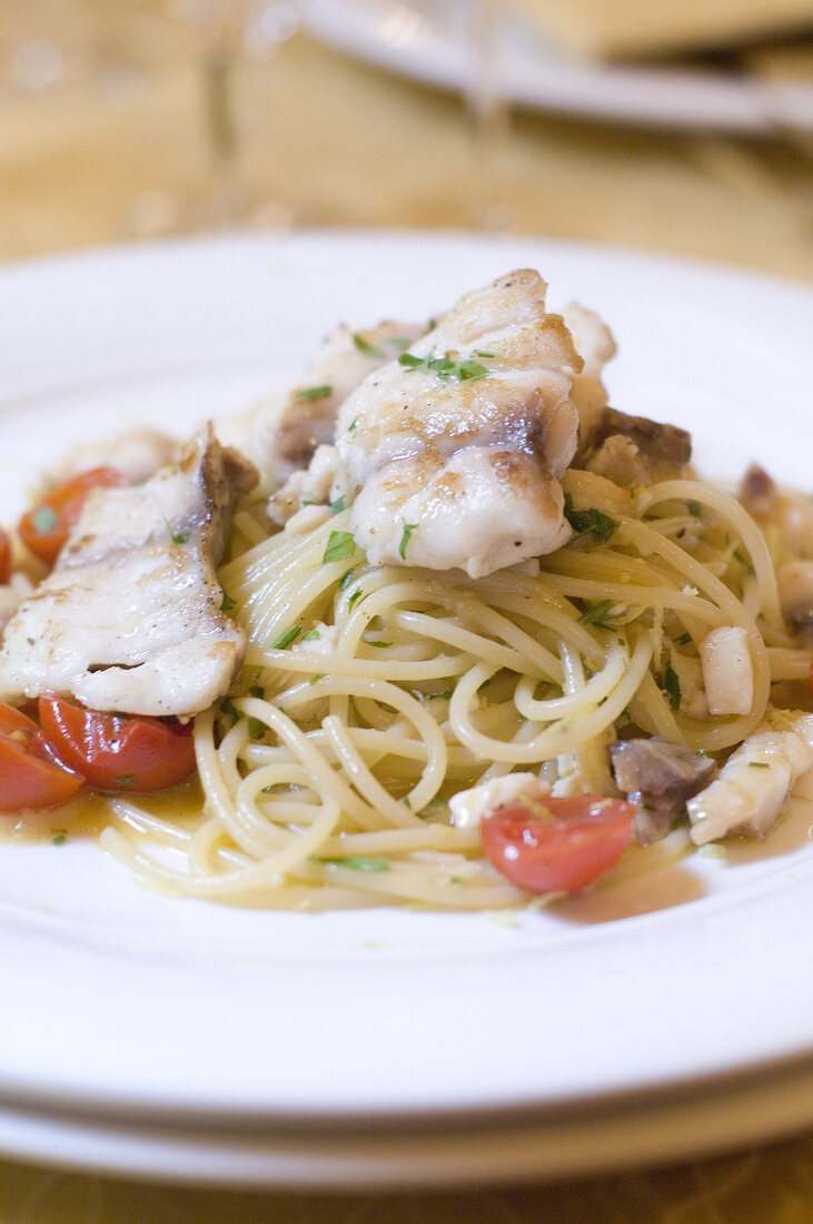 Close-up of pasta with grouper fish and cherry tomatoes on plate