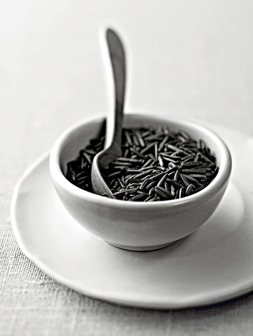 Wild rice in bowl with spoon, black and white
