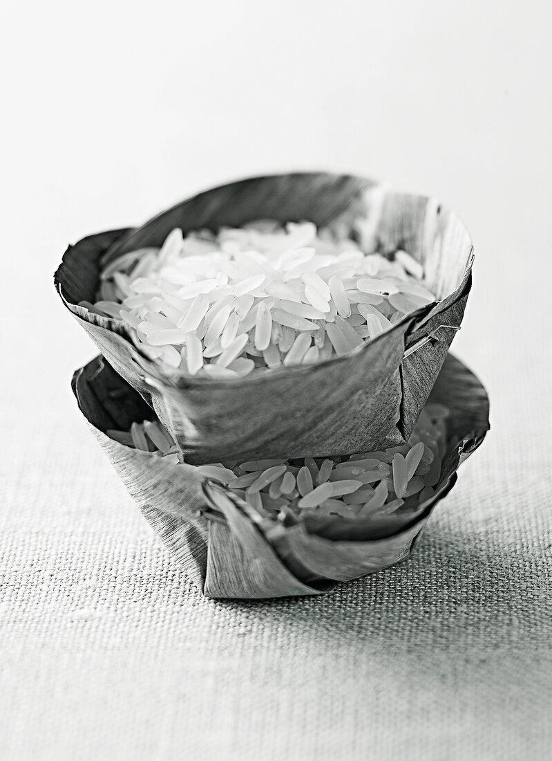 White parboiled rice in leaf bowls, black and white