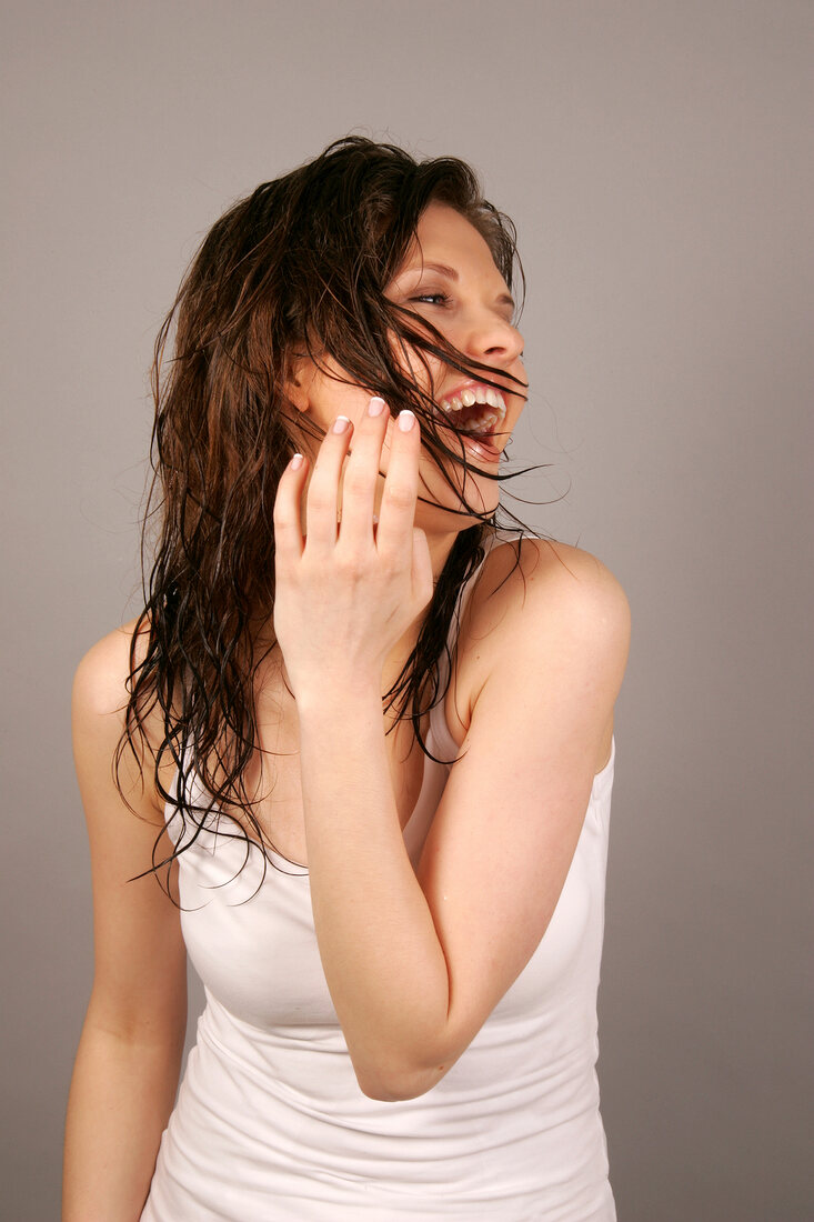 Ecstatic Magdalena woman with wet brown hair looking sideways, laughing