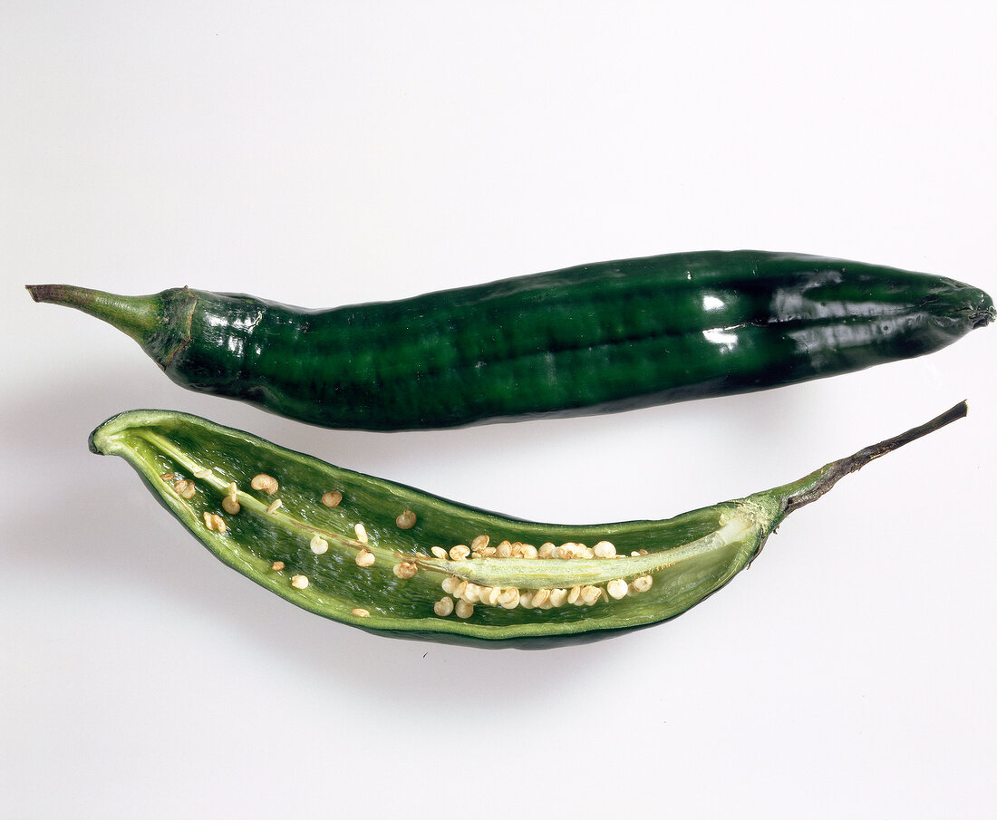 Close-up of halved and whole chilli chilaca on white background