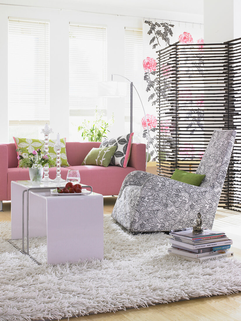 Living room in black and white with pink sofa and bamboo folding screen