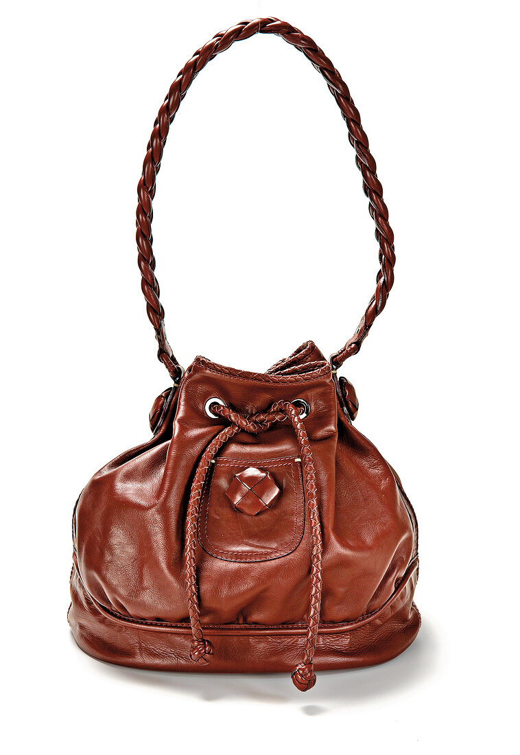 Close-up of brown leather bag with braided handle on white background