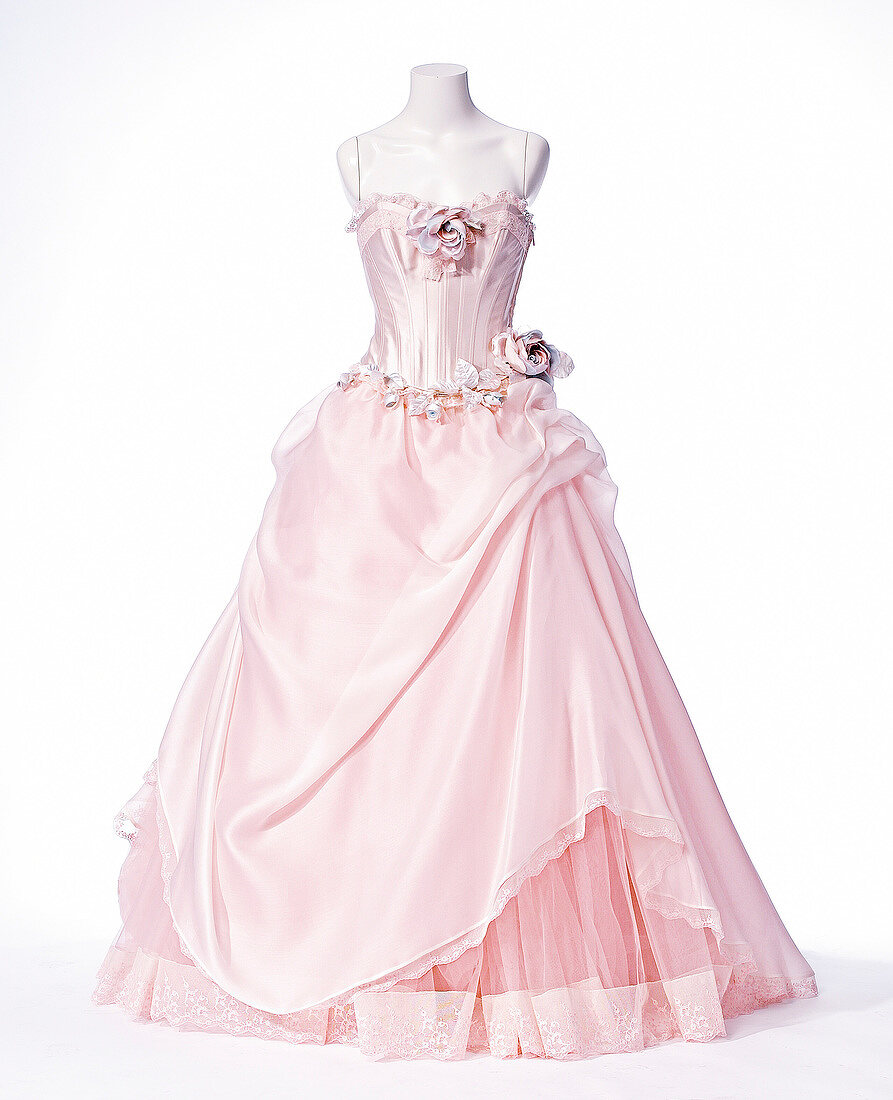 Close-up of pink wedding dress against white background