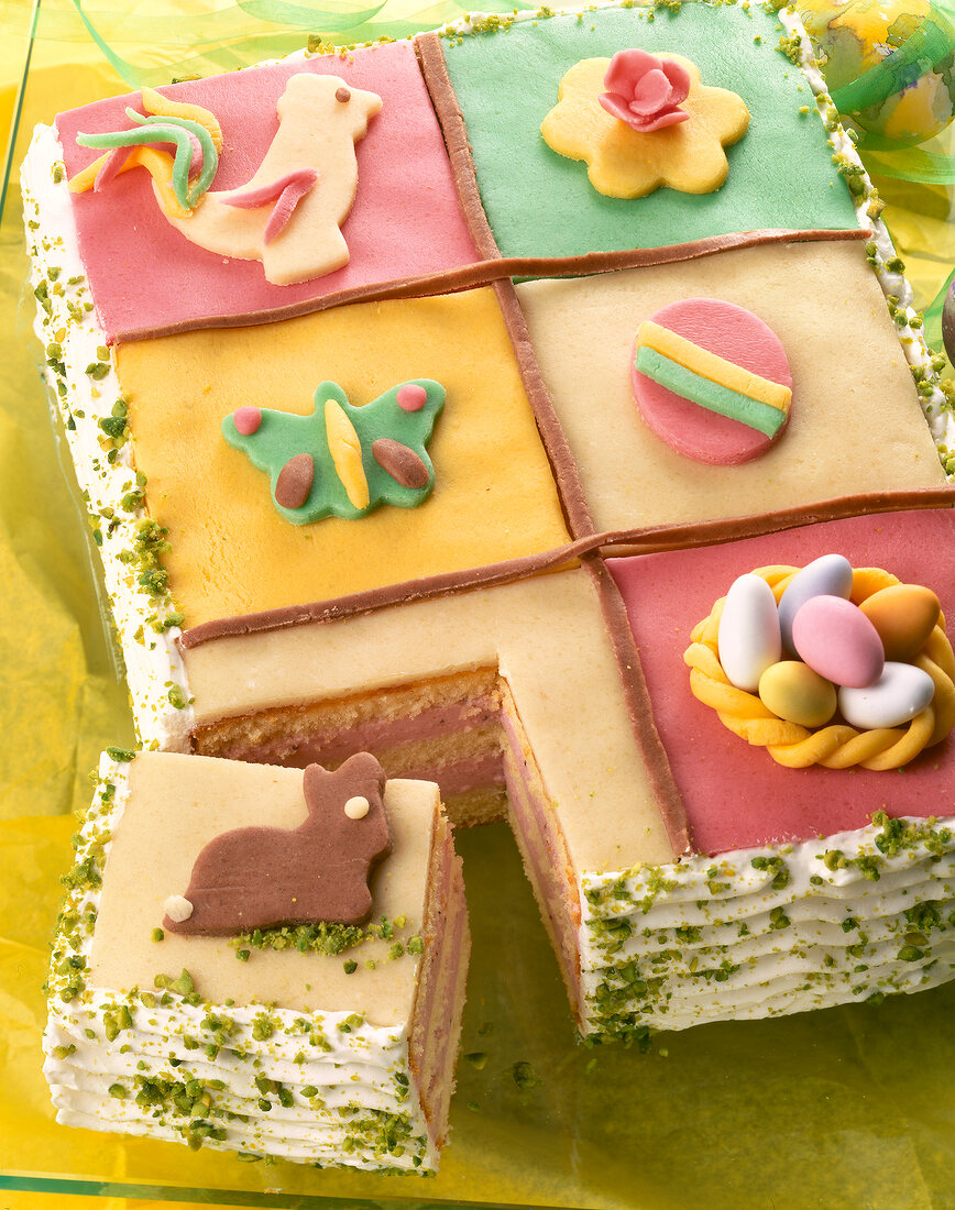 Easter cake with strawberry cream designed with colourful figures made of marzipan
