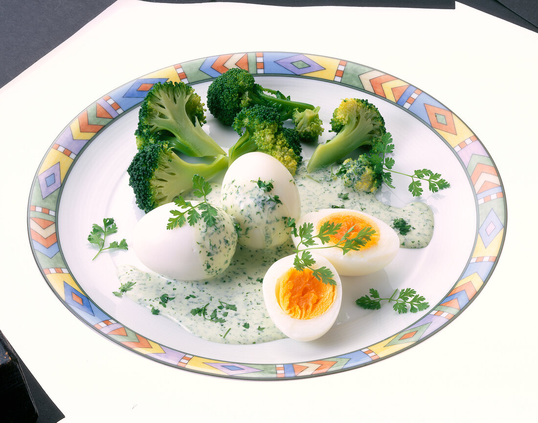 Gekochte Eier mit Brokkoli und Kerbelsauce auf Teller
