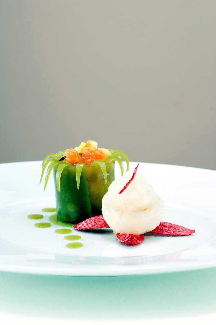 Fruit cocktail with matcha green tea jelly and lychee sorbet on plate