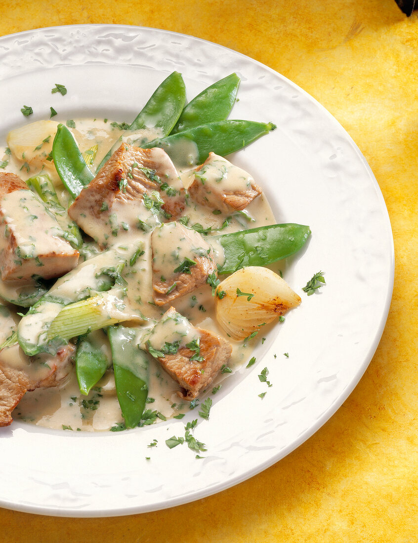 Close-up of veal goulash with sugar snap peas