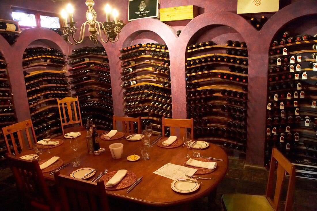 Laid table surrounded with wine racks at Winery Ken Forrester, South Africa