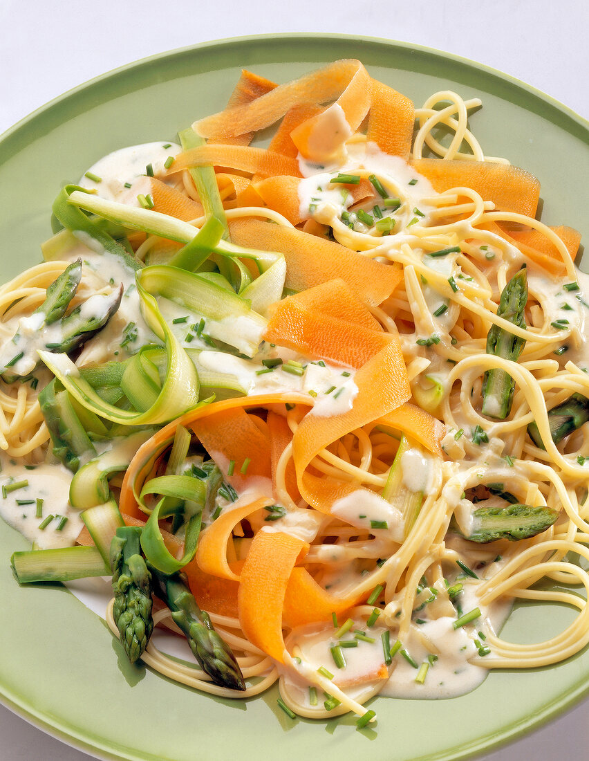 Gemüse-Spaghetti mit Käsesauce auf Teller, mit Spargel
