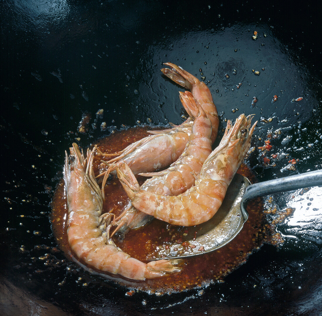Shrimp being cooked in tomato sauce and soy sauce in wok, step 4