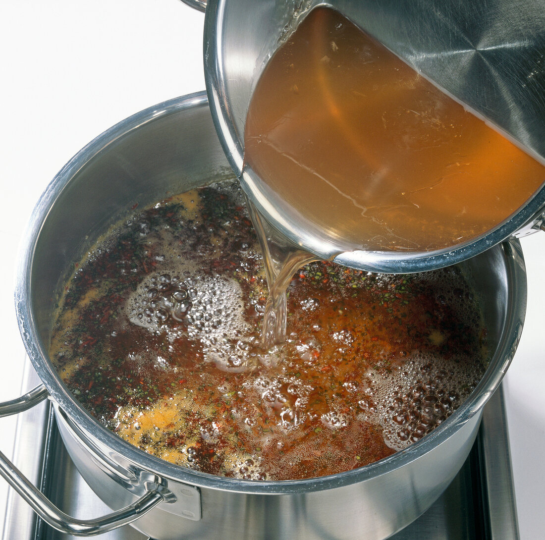 Adding apple juice to mixture of chilli, onion and sugar in casserole, step 2