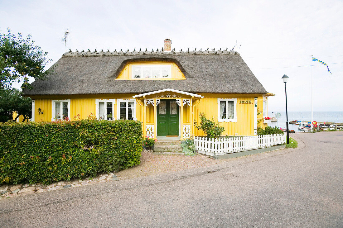 Yellow painted house at harbour in fishing village Arild, Oresund, Sweden