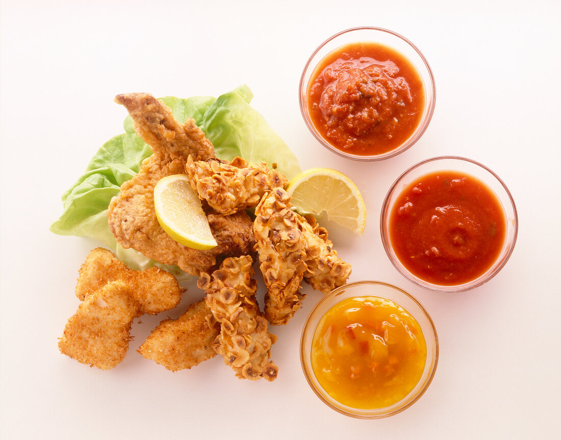 Fried chicken salad with breaded, lemon and dips sauce on white background