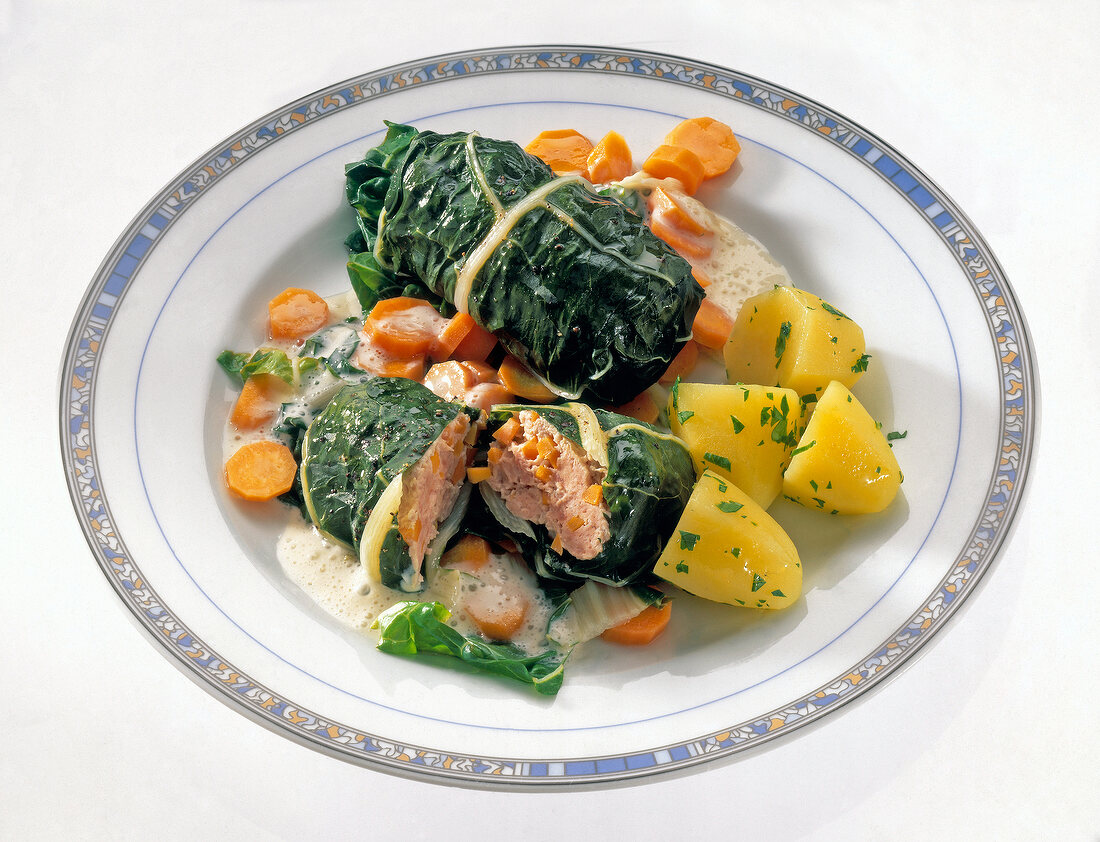 Chard roulade with potatoes and carrots on plate