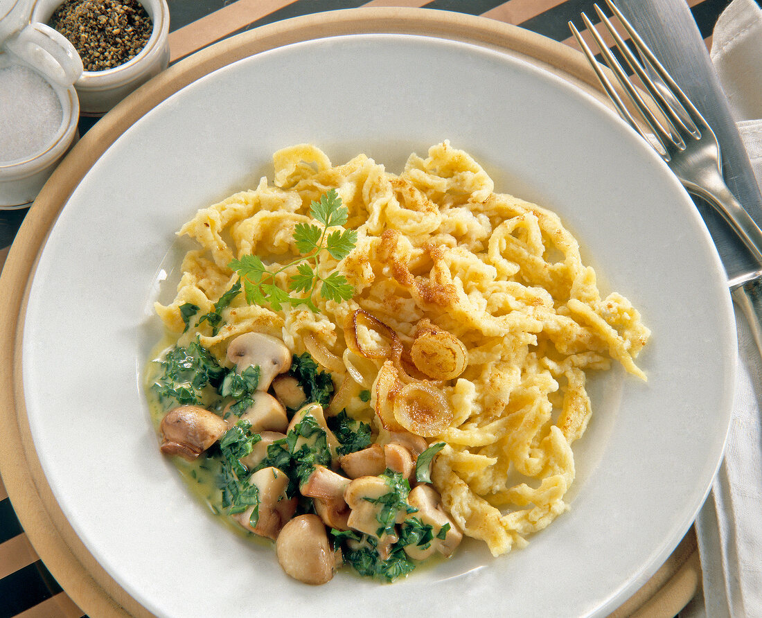 Close-up of mushroom noodles with vegetables and herbs on plate