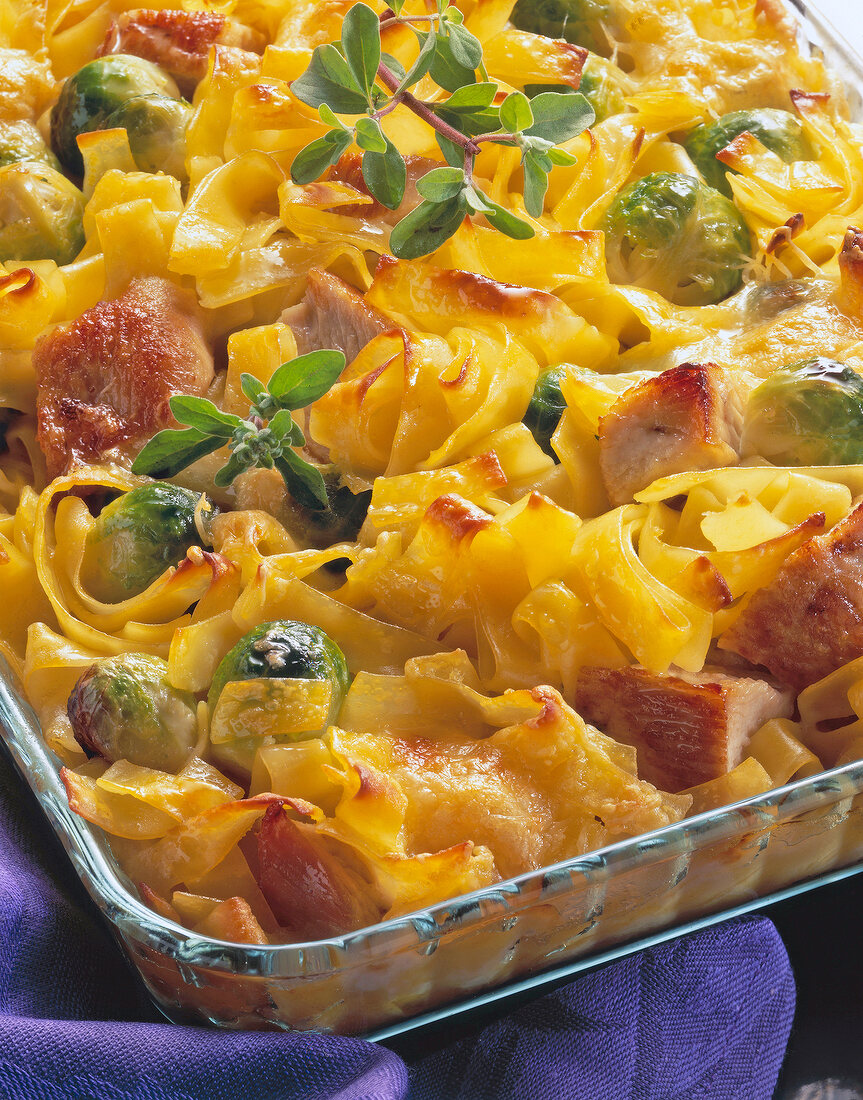 Close-up of pasta gratin with chicken and Brussels sprouts on tray