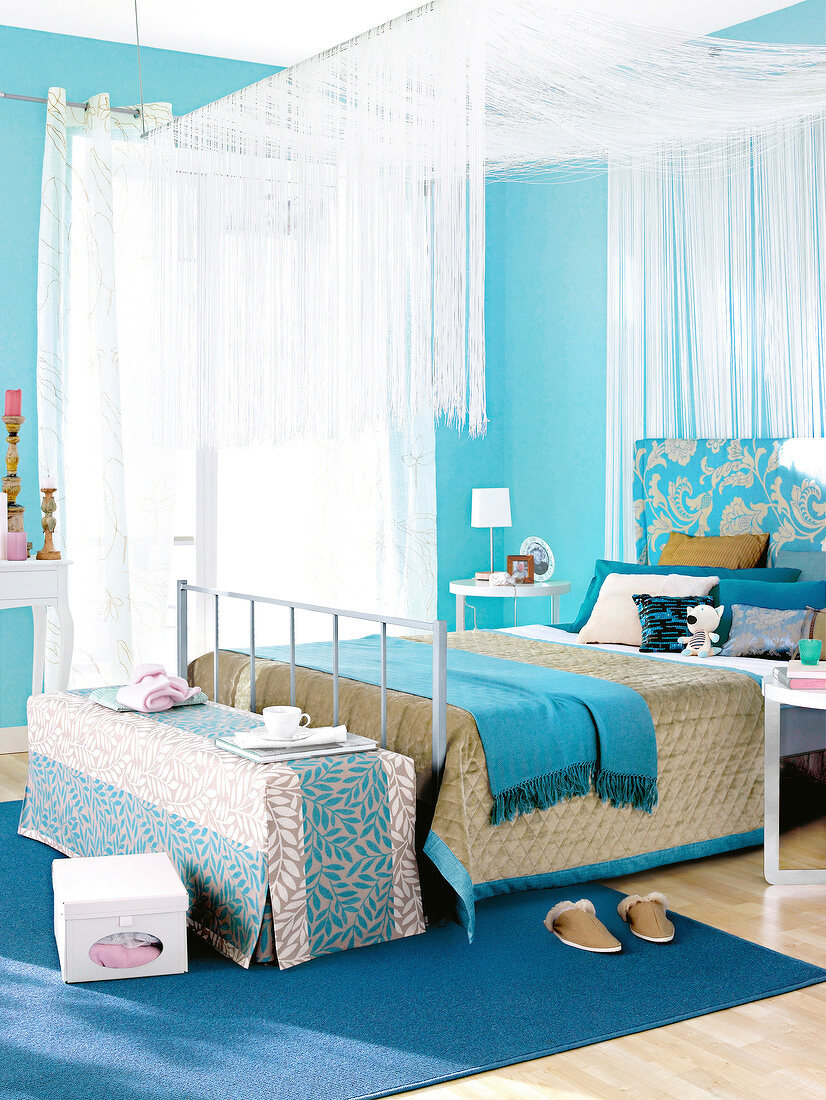 Blue canopy bed and carpet in bedroom