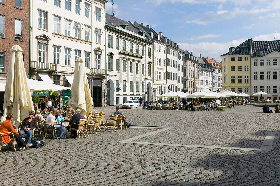 People sitting at cafe in Nytorv Square, Copenhagen, Denmark