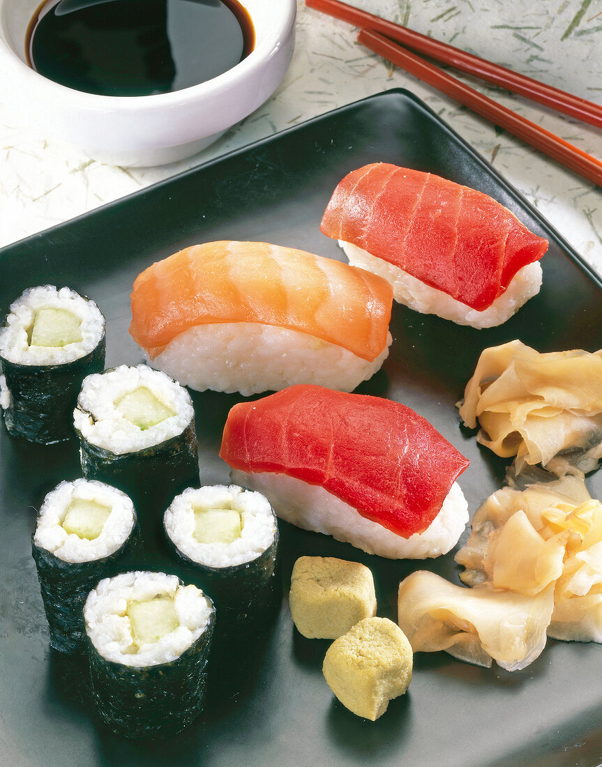 Sushi with salmon, tuna, cucumber and wasabi sauce on serving dish
