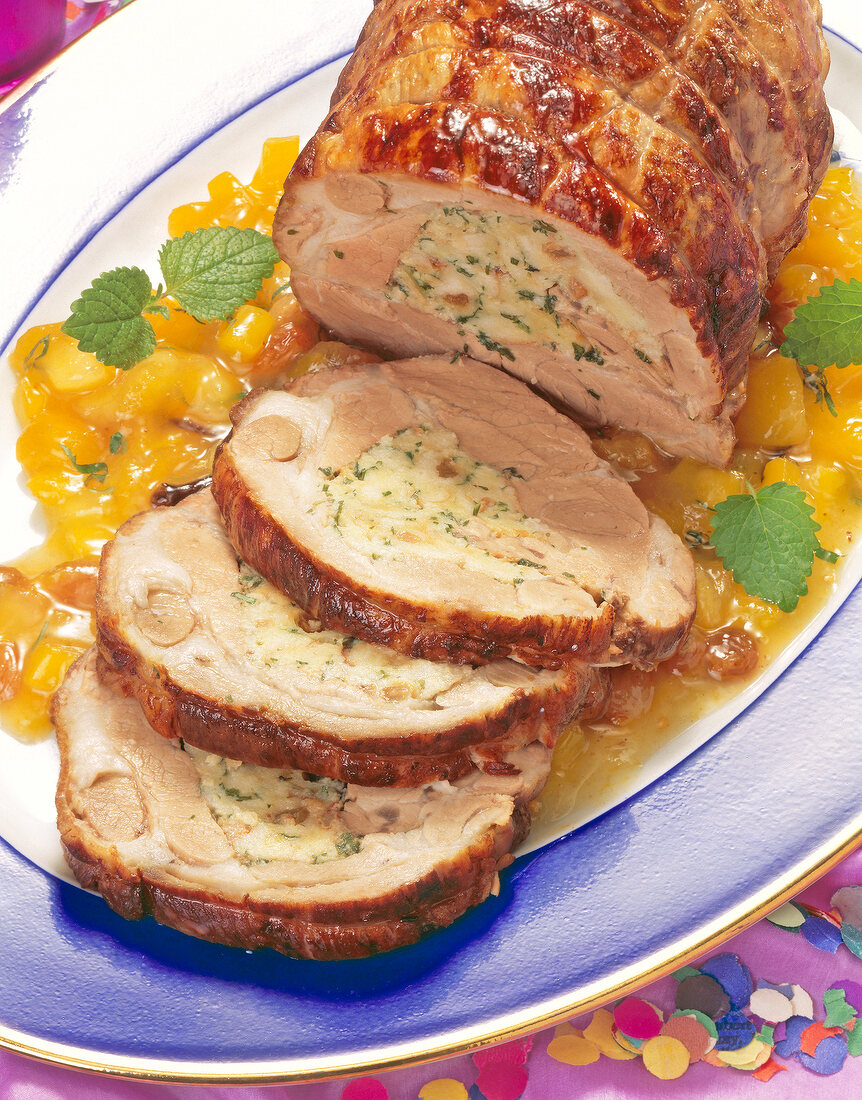 Close-up of pork roast roll with chutney on plate