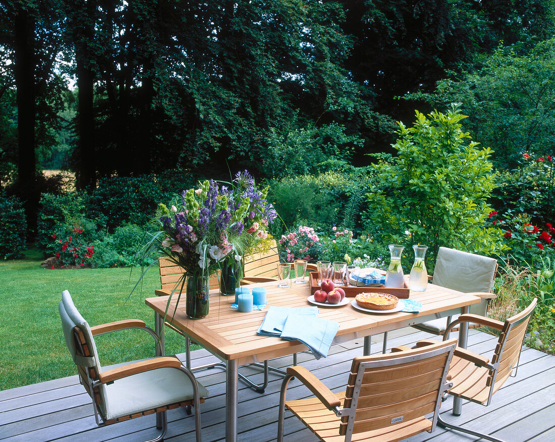 Wooden table and chair with flower vases in garden